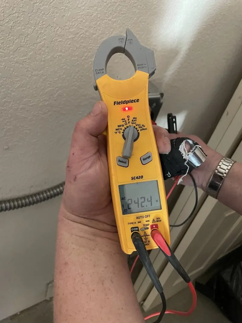 Voltage testing with clamp meter during Whole House Surge Protector in Great Neck Plaza